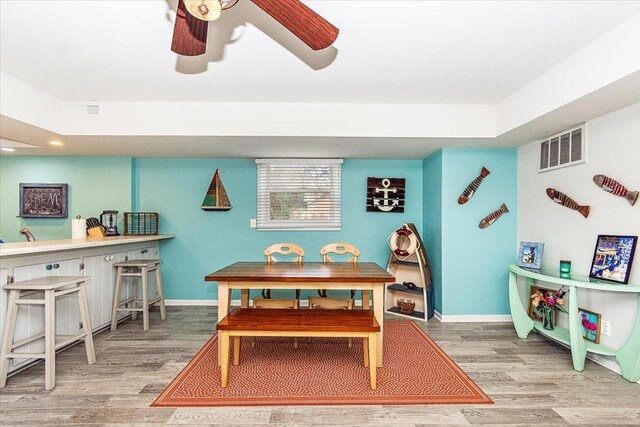 dining space with hardwood / wood-style flooring and ceiling fan