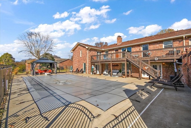 back of property with a gazebo, a swimming pool side deck, and a patio