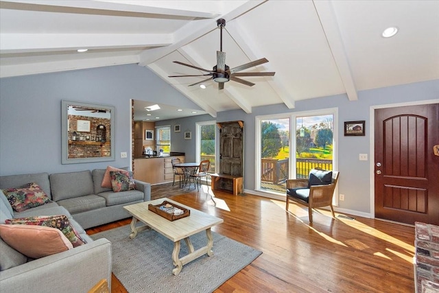 living room featuring vaulted ceiling with beams, ceiling fan, and light hardwood / wood-style flooring