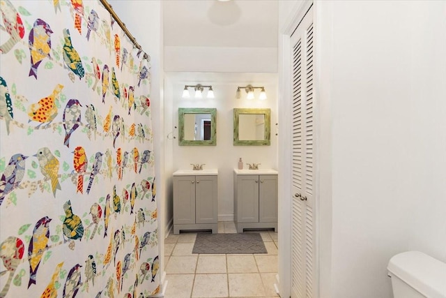 bathroom featuring tile patterned flooring, vanity, and toilet