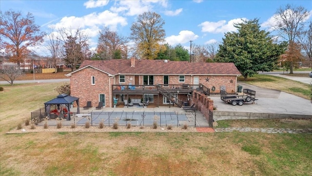 rear view of house featuring a gazebo, a patio area, a deck, and a lawn