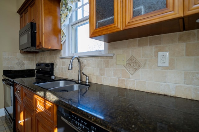 kitchen with dark stone countertops, sink, decorative backsplash, and black appliances