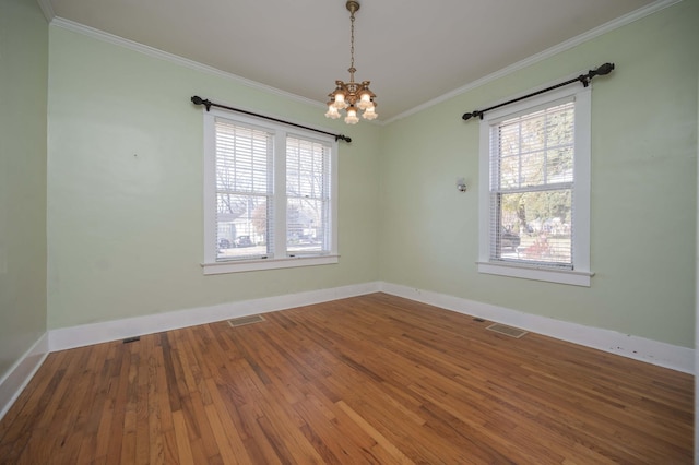 unfurnished room with crown molding, a notable chandelier, and hardwood / wood-style flooring