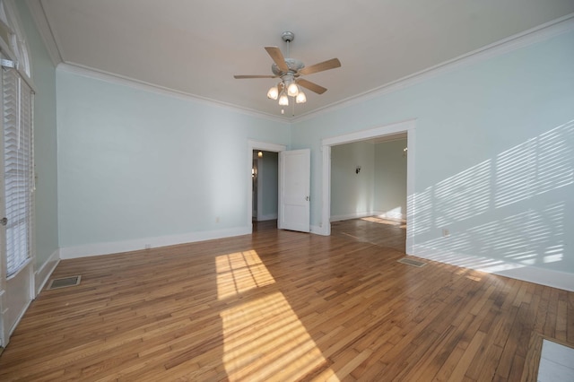 empty room with hardwood / wood-style floors, crown molding, and ceiling fan