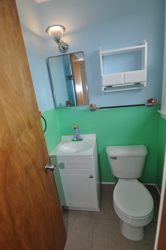 bathroom with tile patterned flooring, vanity, and toilet