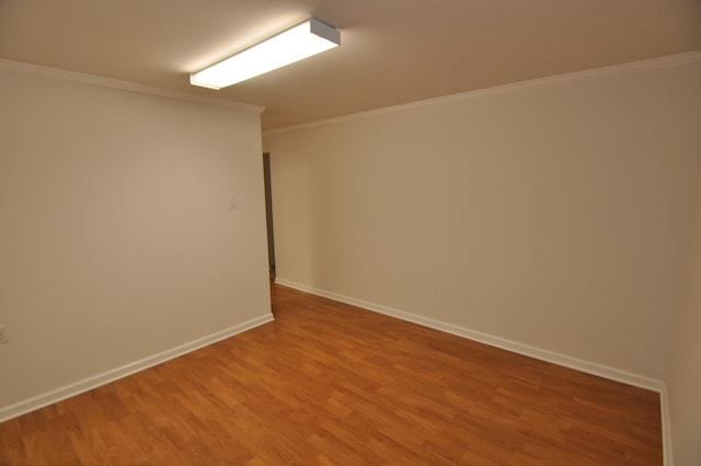 empty room with ornamental molding and wood-type flooring