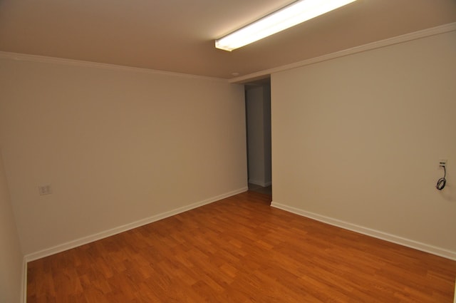 spare room with hardwood / wood-style flooring and crown molding