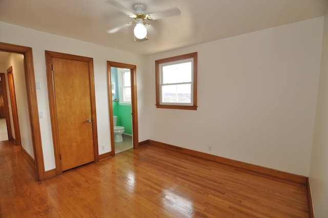 unfurnished bedroom with ceiling fan, ensuite bathroom, and light hardwood / wood-style floors