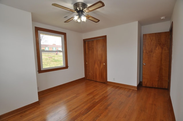 unfurnished bedroom featuring wood-type flooring, ceiling fan, and a closet