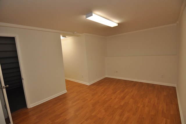 empty room featuring hardwood / wood-style flooring and ornamental molding