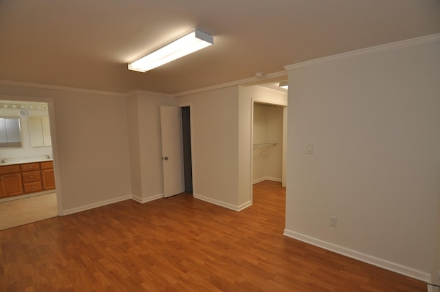 unfurnished room with ornamental molding and light wood-type flooring