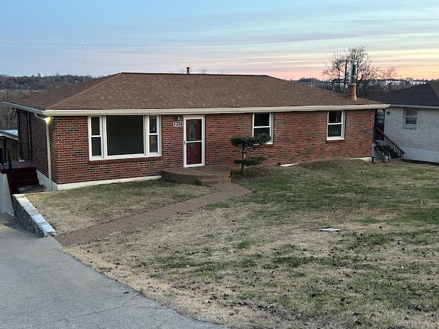 ranch-style home featuring a lawn