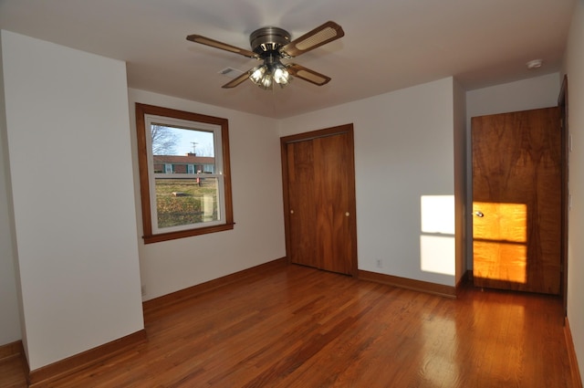 unfurnished bedroom featuring hardwood / wood-style floors, ceiling fan, and a closet