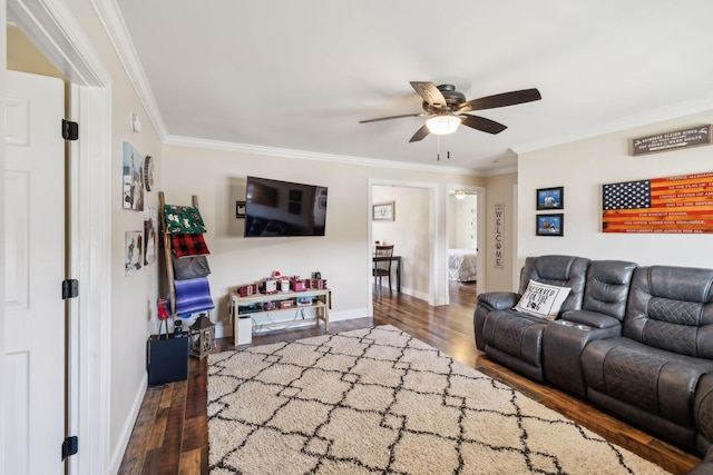 living room featuring ceiling fan, ornamental molding, and dark wood-type flooring