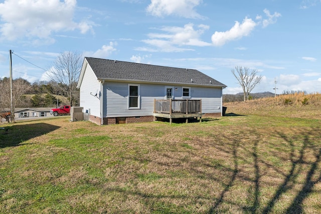 rear view of house featuring a deck and a lawn