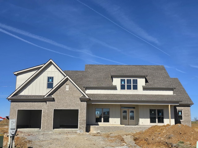 view of front of house with a garage, french doors, board and batten siding, and a shingled roof