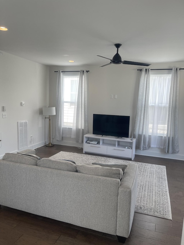 living room featuring ceiling fan and dark hardwood / wood-style floors