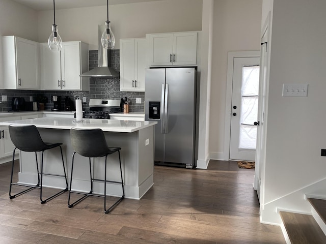 kitchen featuring dark wood-type flooring, appliances with stainless steel finishes, a kitchen island with sink, and white cabinets