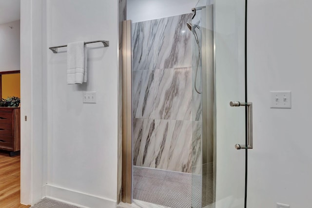 bathroom featuring hardwood / wood-style floors and a shower with shower door