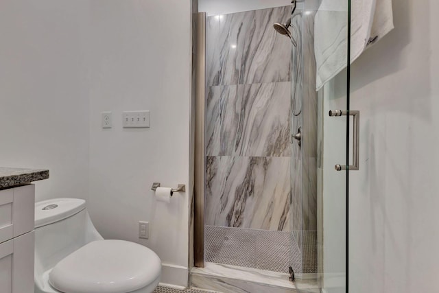 bathroom with toilet, vanity, and tiled shower