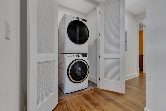 laundry area featuring light wood-type flooring and stacked washing maching and dryer