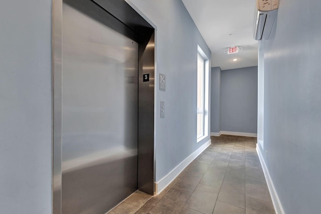 hallway with a wall mounted air conditioner, light tile patterned floors, and elevator