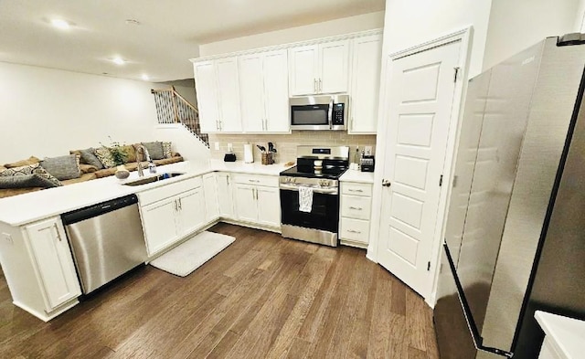 1528 Cedarbrooke Ln, Lebanon, TN 37090 - kitchen featuring appliances with stainless steel finishes, dark wood-style flooring, white cabinets, a peninsula, and recessed lighting