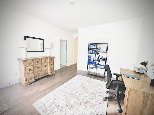 home office with light hardwood / wood-style flooring