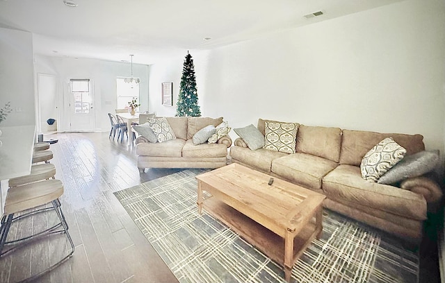 living room featuring wood-type flooring and a notable chandelier