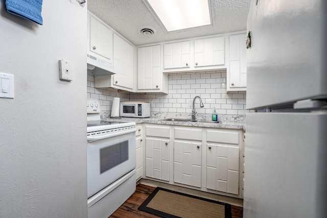 kitchen with backsplash, sink, white appliances, a textured ceiling, and white cabinets