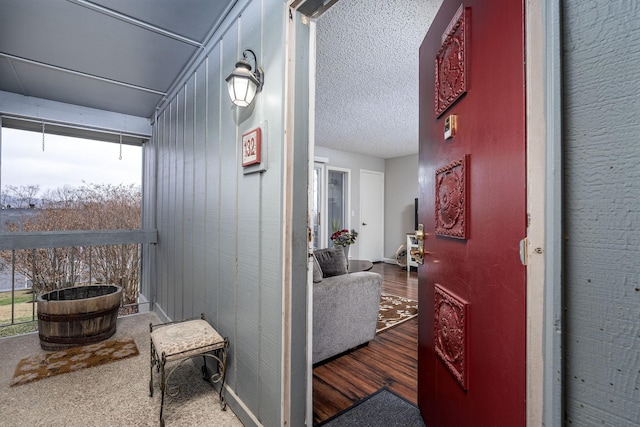 hallway with hardwood / wood-style floors and wood walls