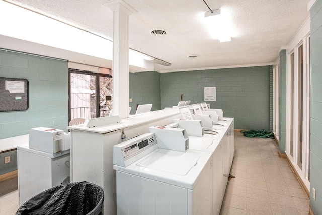 clothes washing area with washer and clothes dryer and a textured ceiling