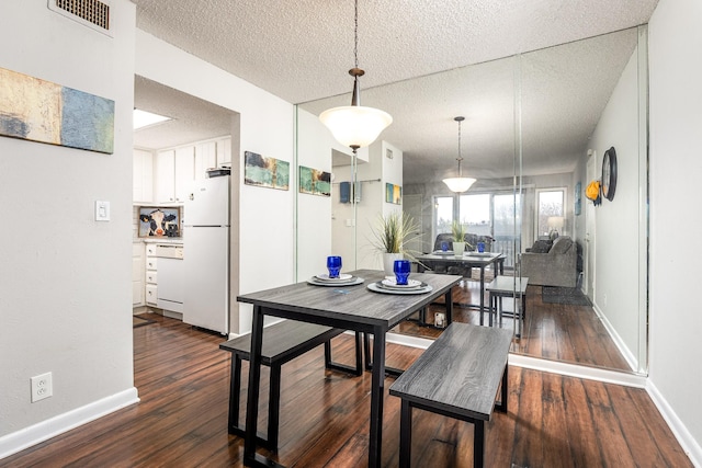 dining room featuring a textured ceiling and dark wood-type flooring