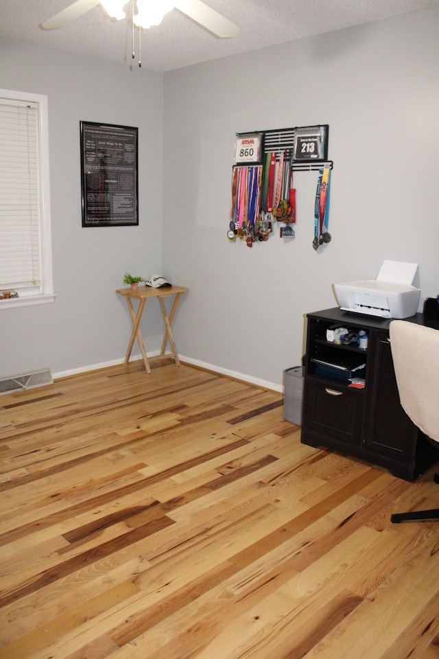 office area featuring ceiling fan, wood-type flooring, and a textured ceiling