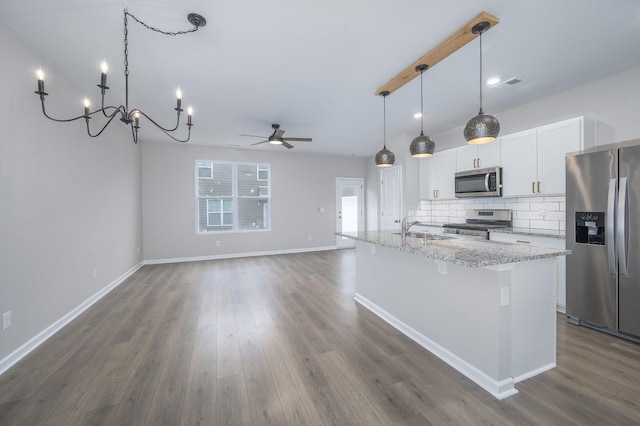 kitchen featuring tasteful backsplash, a center island with sink, appliances with stainless steel finishes, light stone countertops, and white cabinets