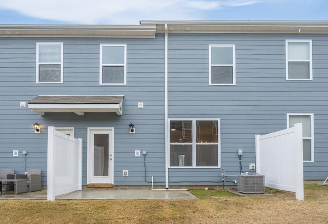 back of property with a patio, central AC, and a lawn