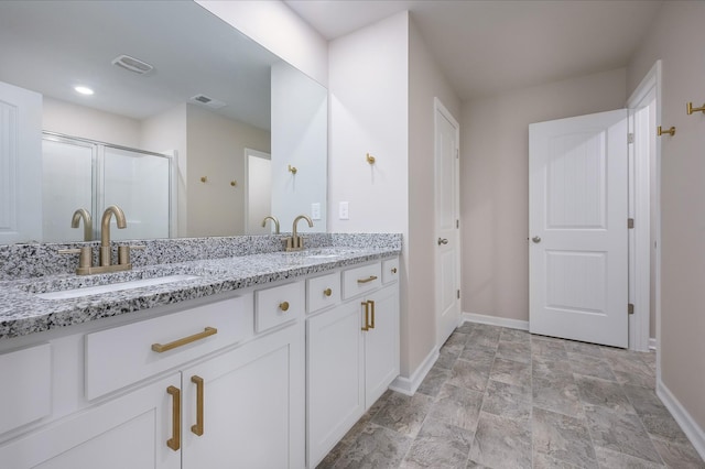 bathroom with vanity and a shower with shower door