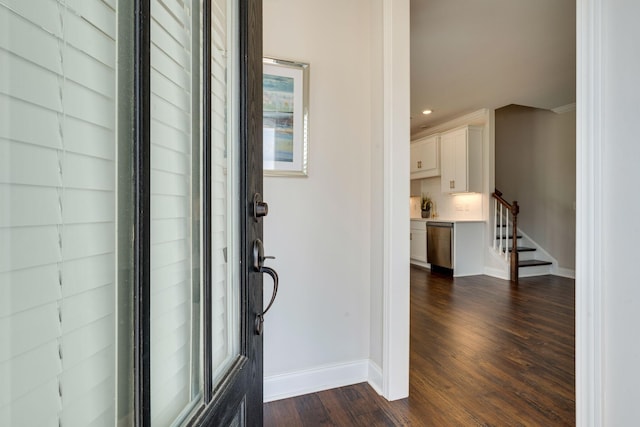 entrance foyer with dark hardwood / wood-style flooring and crown molding