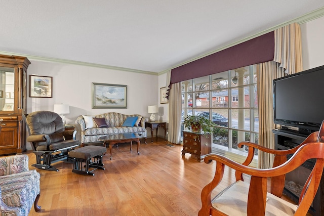 living room with light wood-type flooring and crown molding