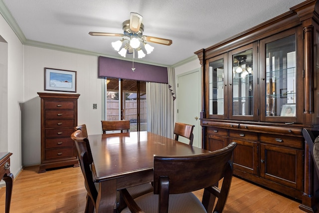 dining space featuring a textured ceiling, light hardwood / wood-style floors, ceiling fan, and crown molding