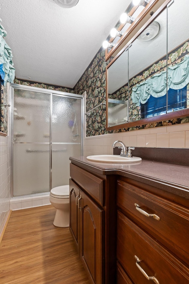 bathroom with vanity, hardwood / wood-style flooring, toilet, and tile walls