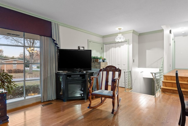 living room featuring hardwood / wood-style flooring, a wealth of natural light, and ornamental molding