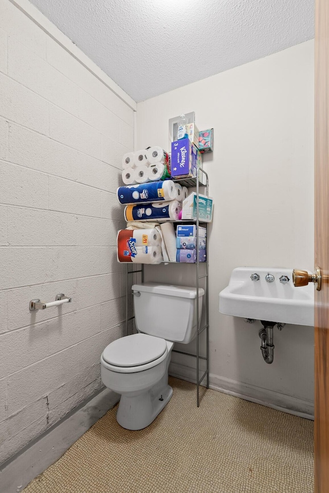 bathroom featuring sink, toilet, and a textured ceiling