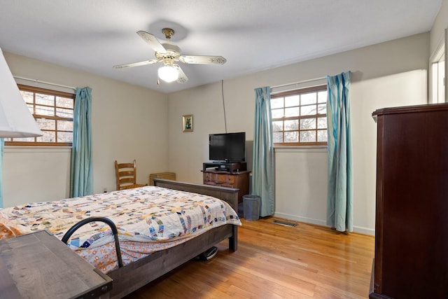 bedroom with multiple windows, ceiling fan, and light wood-type flooring