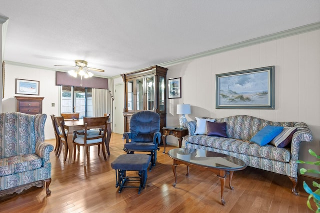 living room featuring a textured ceiling, hardwood / wood-style flooring, ceiling fan, and crown molding