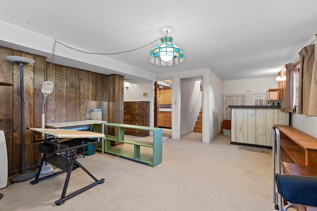 dining area with wooden walls and light colored carpet