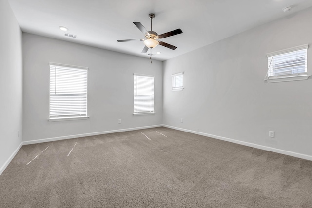 carpeted spare room featuring ceiling fan