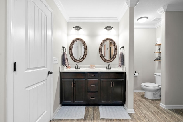 bathroom featuring vanity, toilet, wood-type flooring, and ornamental molding