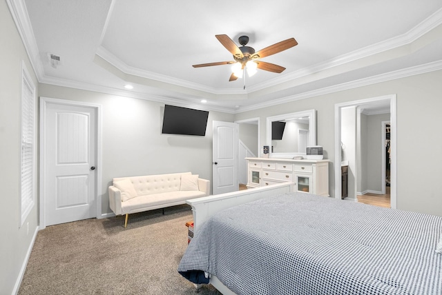 carpeted bedroom featuring ceiling fan, ornamental molding, and a tray ceiling