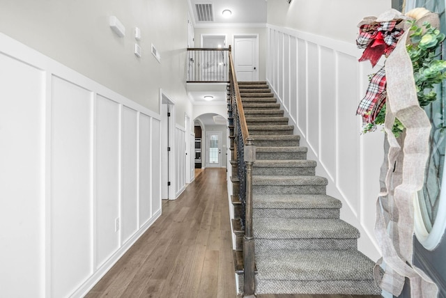 stairs featuring hardwood / wood-style floors and crown molding